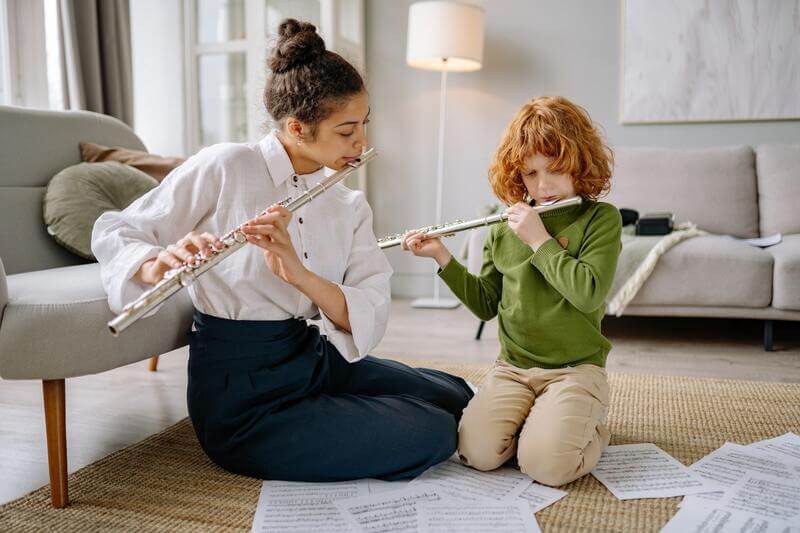 an instructor and her student are playing flute duets
