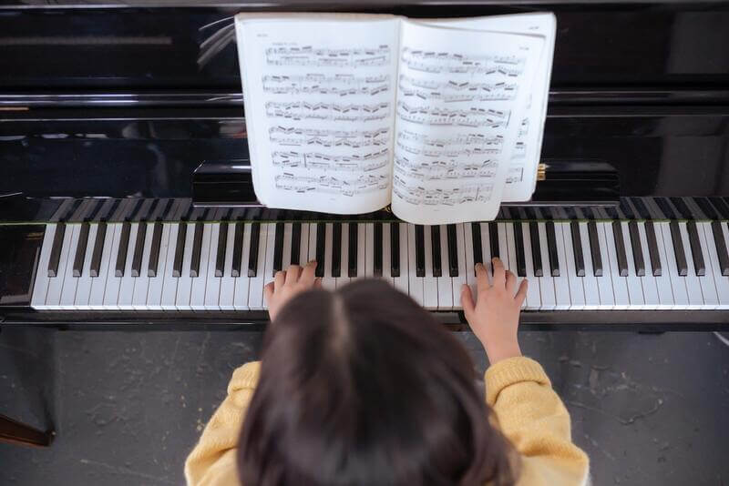 a pianist is playing the piano with a sheet music book open